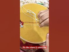 someone is stitching something on a yellow piece of fabric