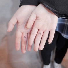 two fingers with small tattoos on them and one has the word love written on it