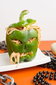 a green pepper with noodles in it on a plate