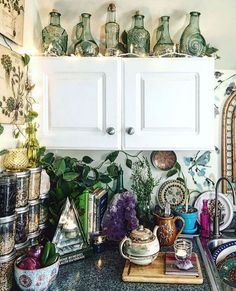 a kitchen counter topped with lots of pots and pans next to a white cabinet