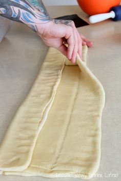 a person is rolling out dough on a table