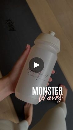 a person holding a baby bottle in their hand with the words monster walks on it