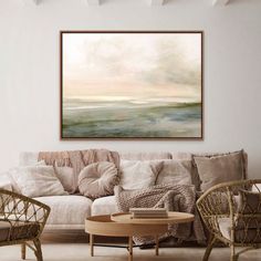 a living room filled with furniture and a painting hanging on the wall above it's coffee table