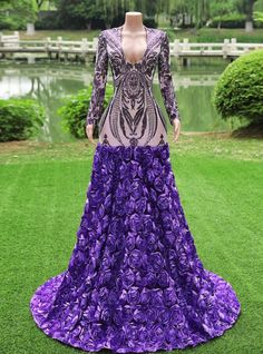 a mannequin wearing a purple dress with flowers on the skirt and long sleeves