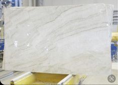 a large marble slab in a factory with some yellow and white boxes on the floor