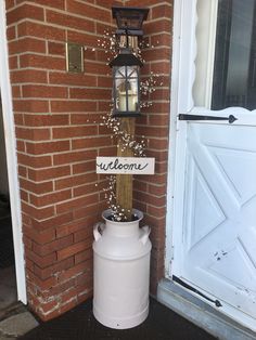 Old Door On Porch Decorating Ideas, Decorating Old Milk Cans, Welcome Sign Ideas Front Porches, Farmhouse Yard Decor Country, Country Welcome Signs Front Porches, Milk Can Projects, Diy Back Porch Decor, Spring Milk Can Decor, Vintage Front Porch Decor