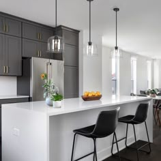 a kitchen with two bar stools next to an island