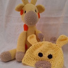 two crocheted giraffes sitting next to each other on a white background