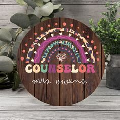 a wooden sign with the words, counselor mrs stevens on it next to potted plants