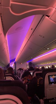 the inside of an airplane with people sitting on seats