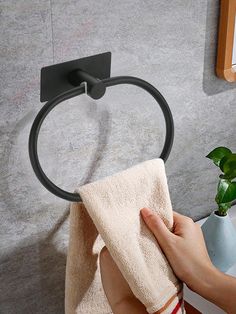 a person is holding a towel in front of a sink with a black ring on it