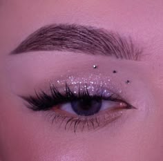 a woman with long lashes and glitters on her eyes