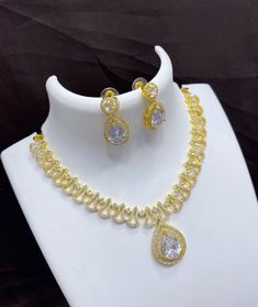 This exquisite Tending Gold plated American Diamond necklace and earring set makes an ideal choice for weddings and more. The necklace features an oval shaped AD stone locket and comes with matching earrings for a complete look. Crafted with the highest quality materials, this jewelry set is sure to sparkle and shine. American Diamond Necklaces, Necklace Bridal, Kundan Necklaces, Cz Jewelry, Wedding Jewellery Necklace, American Diamond, Pretty Earrings, Bridal Necklace, Necklace Earring Set