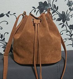 Crossbody Bucket bag, Vegan Suede Bucket Bag, Vegan Leather Bucket Bag for women,  Leather Bag, Handbag, Leather Crossbody Bag, Purse Women Vegan suede and leather crossbody bucket bag with ellipse shaped bottom. The Bucket bags are available in high quality Vegan Suede and in Vegan leather too.  Please note that suede and leather models are a little bit difference:   Suede bucket bags have only NOT DETACHABLE long  adjustable crossbody  strap (NO SHORT HANDLE )  Leather bucket bags have detachable adjustable crossbody strap and short handle. You may find this bag in other colors in vegan suede and in genuine suede too in my shop: https://www.etsy.com/shop/LIONDO?ref=cart_shop_name_click&cart_id=4053747673&section_id=26104071. Its size is ideal for holding your basic necessities such as ph Brown Suede Bag, Vegan Purses, How To Make Brown, Suede Bag, Handbag Leather, Leather Bucket Bag, Leather Bucket, Women Leather, Bag For Women