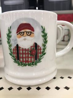 a white coffee mug with a santa clause on it