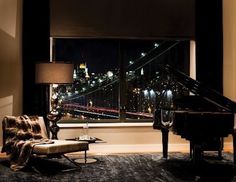 a living room filled with furniture and a grand piano in front of a large window