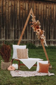 an outdoor seating area with fall decorations and pillows