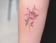 a woman's arm with a flower tattoo on it