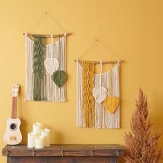 there are two wall hangings on the wall next to a fire place and a plant