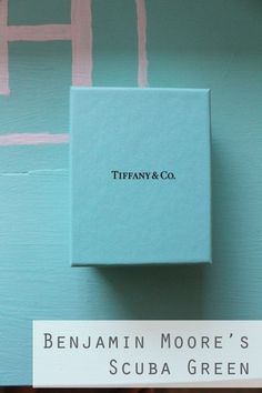 a blue box sitting on top of a wall with the words tiffany & co above it