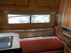 the inside of a camper with a sink, stove and refrigerator in it's corner