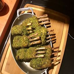 a pan filled with food sitting on top of a wooden tray next to an oven