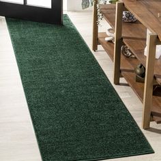 a green rug is on the floor next to stairs