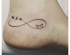 a tattoo on the foot of a woman with two birds flying over it and an infinite love