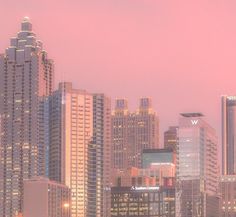 the city skyline is lit up at night, with skyscrapers in the foreground