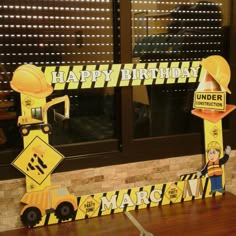 a construction themed birthday party with paper cutouts and construction signs on the windowsill