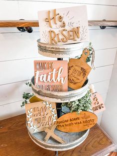 a three tiered cake with wooden signs on it