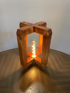 a wooden table with a lit candle on it and a light in the middle that is shaped like an octagon