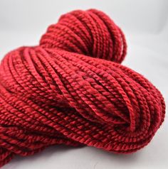 a skein of red yarn on a white surface