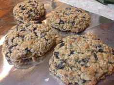 four oatmeal cookies sitting on top of a piece of tin foil