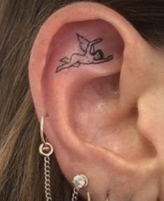 a woman with a small tattoo behind her ear