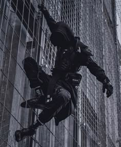 a man is jumping in the air on a skateboard near a fence and tall buildings