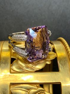 Not all amethyst rings are created equal... obviously. Crafted in 18K white gold, this ring is centered by an approximately 21ct fantasy cut amenthyst which is surrounded by approximately 1.84cttw in pavé set H-I color Si1-i1 clarity round diamonds. An amethyst ring that is bright and full of life! Dimensions/Weight: Ring measures .70" top to bottom and .90" wide and weighs 16g. Condition: All stones are secure and this ring has been freshly polished. The amethyst is chipped in two places on the Amethyst Rings, Diamond Cocktail Ring, Diamond Cocktail Rings, Amethyst Ring, Cocktail Ring, Cocktail Rings, Pave Diamonds, Rings Statement, Round Diamonds