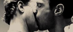 a man and woman kissing each other in black and white