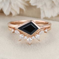 an engagement ring with black onyxite surrounded by white diamonds and rose gold accents