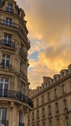 an old building with balconies and balcony railings in front of a cloudy sky