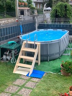 an above ground swimming pool with steps leading up to it and a ladder in the grass