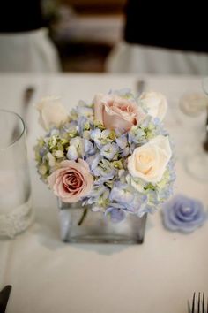 a vase filled with flowers sitting on top of a table next to a knife and fork