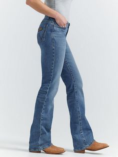 MADE FOR THE ULTIMATE RIDE Allow us to introduce you to Jade—part of the Women's Wrangler® Ultimate Riding Jean collection. This mid-rise relaxed bootcut jean for women is made of a comfortable cotton blend with stretch to keep up with riding, showing, and working. It's enhanced with a slightly pitched waistband that sits lower in the front and higher in the back for maximum comfort and coverage in the saddle as well as our signature no-gap waistband and flat comfort seams. The fit is a little l Affordable Bootcut Jeans, Jeans And Boots Women, Petite Bootcut Jeans, High Waisted Bootcut Jeans Outfit, Western Jeans Womens, Flare Jeans Country, Wallpaper Western, Wrangler Jeans Women's, Wrangler Clothing