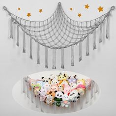 a bunch of small stuffed animals sitting on top of a white plate with tassels hanging from it's sides