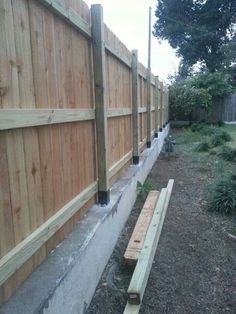 a wooden bench sitting next to a fence