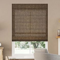 a living room with a couch, chair and window covered in roman blind shades on the windowsill