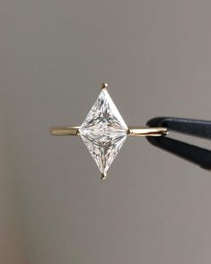 a diamond ring being held up by a pair of scissors