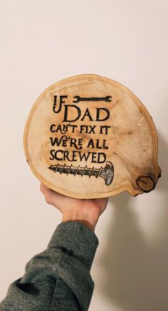 a person holding up a wooden plaque with writing on it that reads, u - dad can't fix it we're all screwed