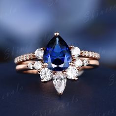 a blue and white diamond ring on top of a black surface with diamonds around it