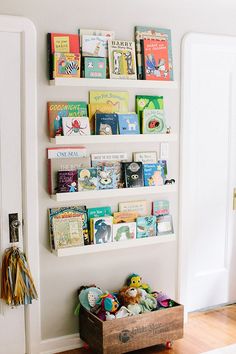 there is a book shelf with many books on it and a wooden crate in front of the wall